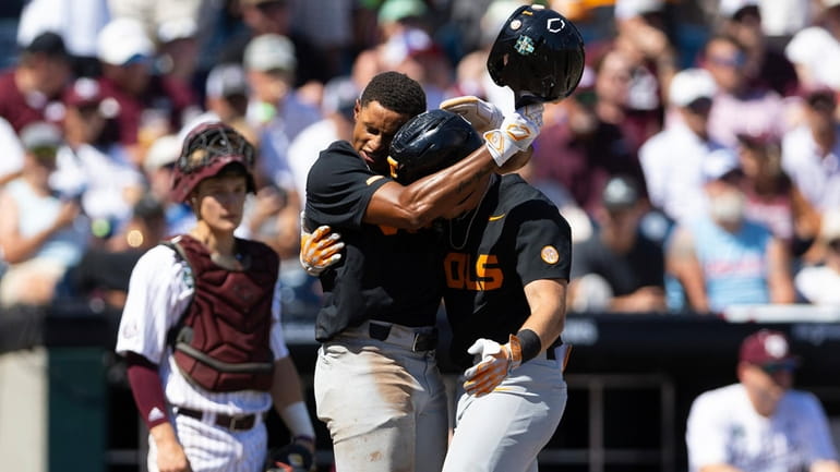 Tennessee's Christian Moore, left, hugs Dylan Dreiling at home plate...