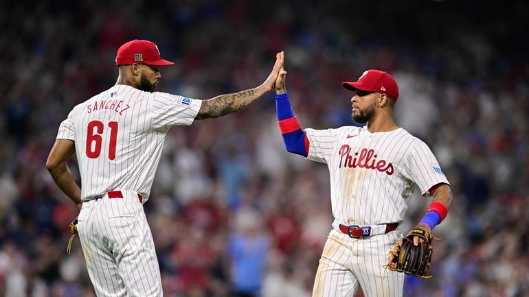 Philadelphia Phillies' Cristopher Sánchez (61) high-fives Edmundo Sosa after Sosa...