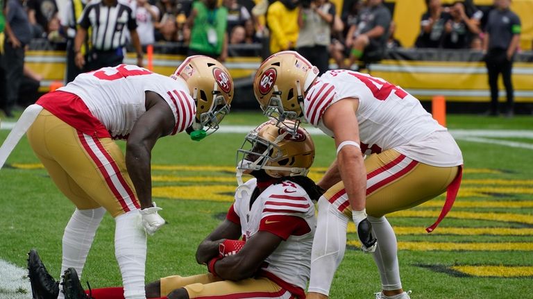 San Francisco 49ers wide receiver Brandon Aiyuk, center, celebrates with...