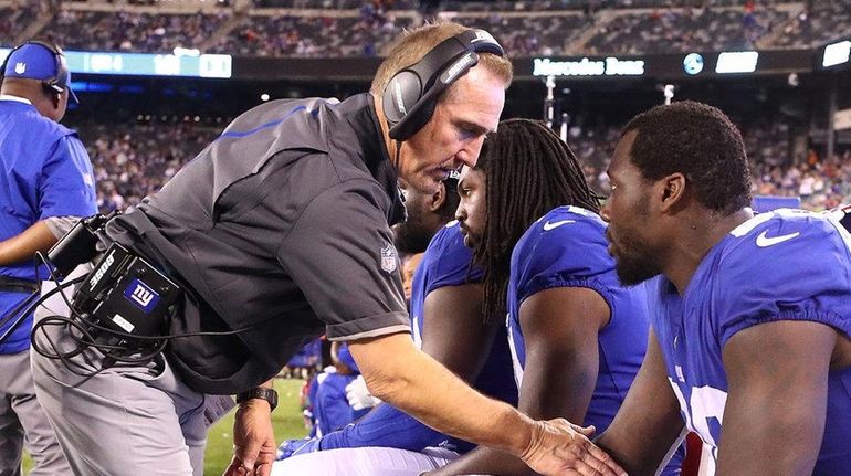 Giants defensive coordinator Steve Spagnuolo talks to Jason Pierre-Paul during...