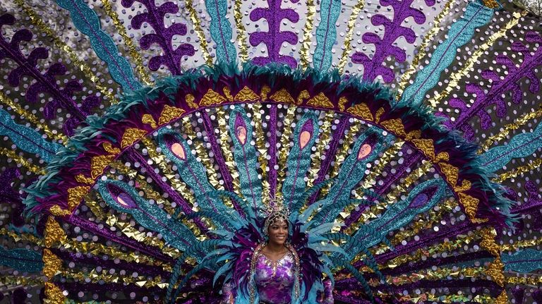 A dancer in costume participate in the West Indian Day...