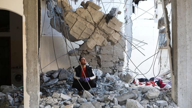 A Palestinian looks at the destruction after an Israeli strike...