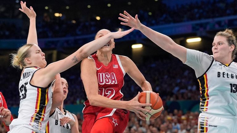 United States' Diana Taurasi, center, shoots as Belgium's Beckey Massey,...