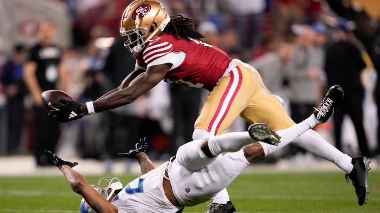 San Francisco 49ers wide receiver Brandon Aiyuk, top, catches a...