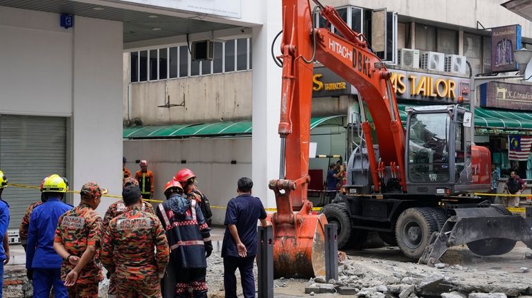 Fire and Rescue department use crane to dig a deep...