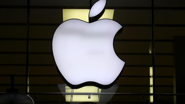 The logo of Apple is illuminated at a store in...