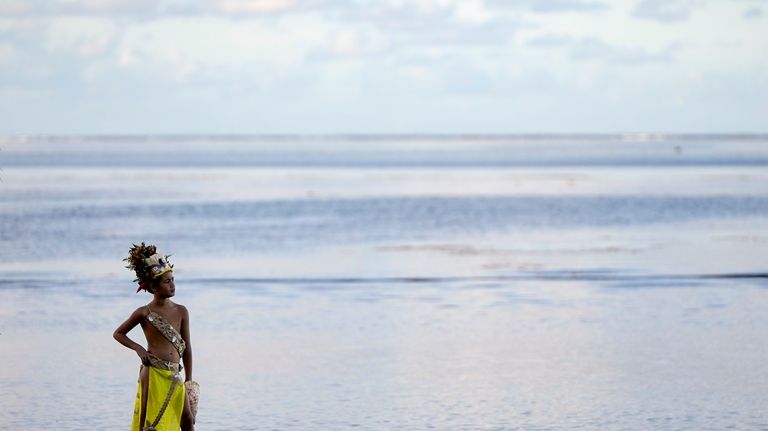 A young dancer waits along the beach before an opening...