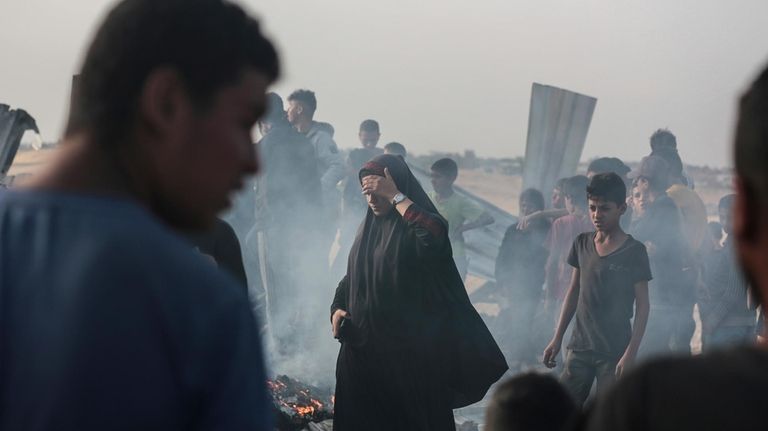 Palestinians look at the destruction after an Israeli strike where...