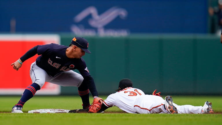 Cleveland Guardians second baseman Andres Gimenez, left, tags out Baltimore...