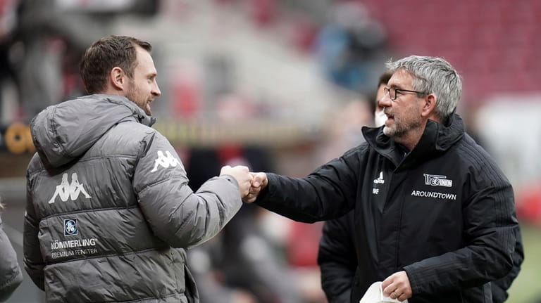 Then Mainz' head coach Bo Svensson, left, greets his Berlin...