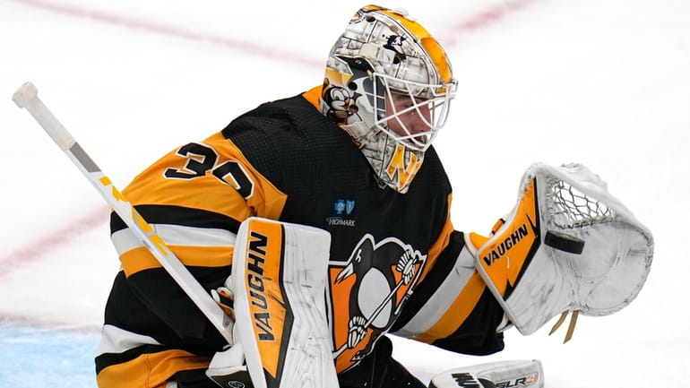 Pittsburgh Penguins goaltender Alex Nedeljkovic gloves a shot during the...