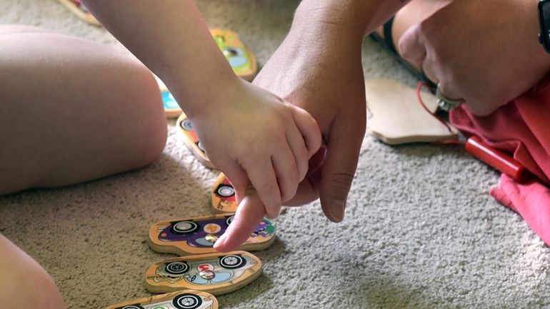 Early Intervention speech pathologist Megan Sanders works with 2-year-old Aria...