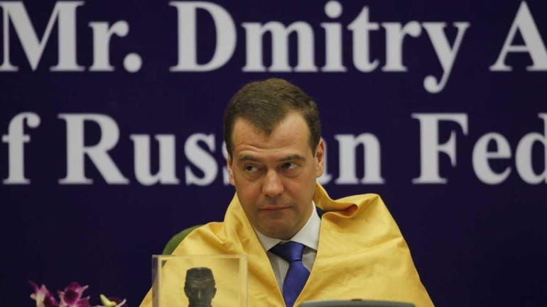 Russian President Dmitry Medvedev looks on after being conferred a...