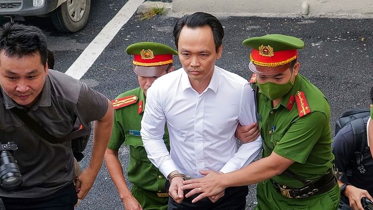 Trinh Van Quyet, a prominent Vietnamese business tycoon, is escorted...