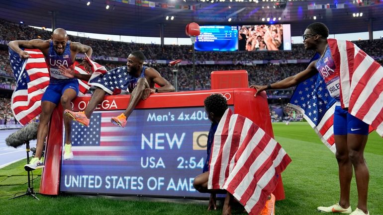 United States' men 4x400-meter relay team celebrates round the race...