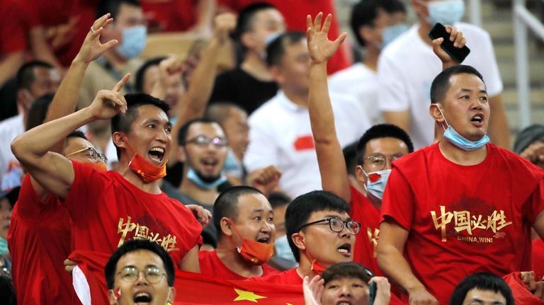 FILE - Chinese soccer fans shout after their national team...