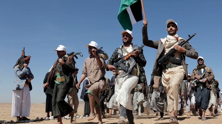 File - Houthi rebel fighters march during a rally of...