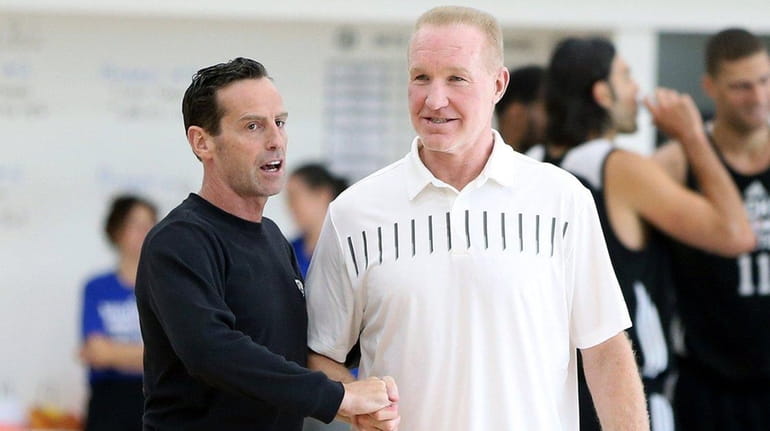 St. John's coach Chris Mullin, right,talks to Nets coach Kenny...