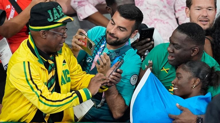 Julien Alfred, of Saint Lucia, poses for pictures with spectators...