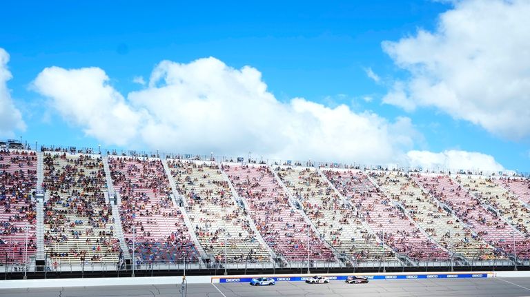 Racing fans watch a NASCAR Cup Series auto race at...