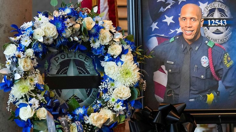 A wreath and a portrait of Dallas police officer Darron...