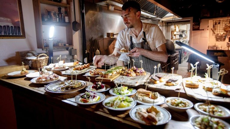 Chef and owner Alexis Trolf replenishes the tapas spread at Lost...