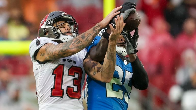 Carolina Panthers safety Xavier Woods intercepts a pass intended for...