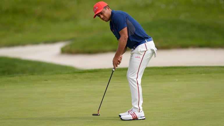 Xander Schauffele, of the United States, putts and makes an...