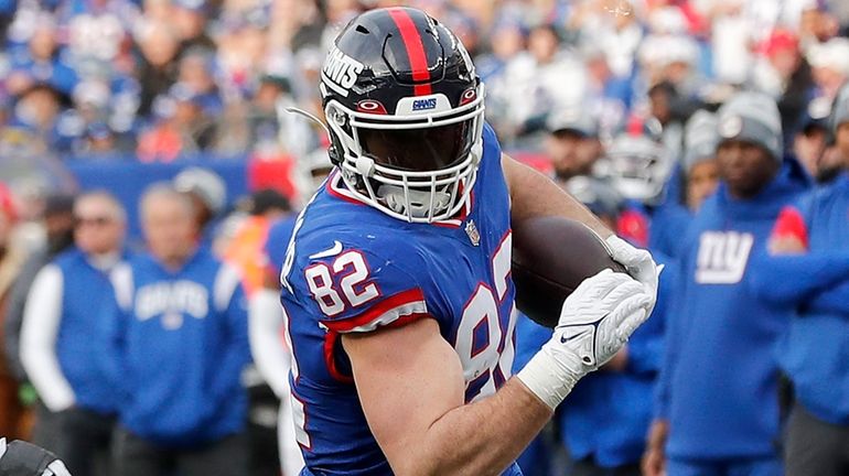 Daniel Bellinger of the New York Giants runs after reception...