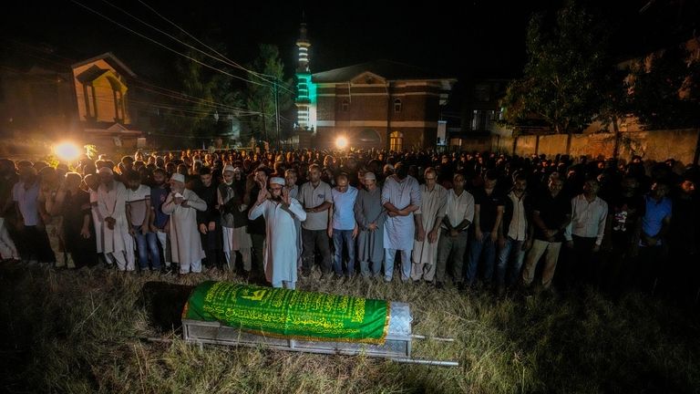 Relatives and colleagues offer prayers in front of the coffin...