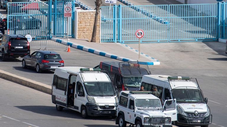 Moroccan security forces stand guard outside the border with the...