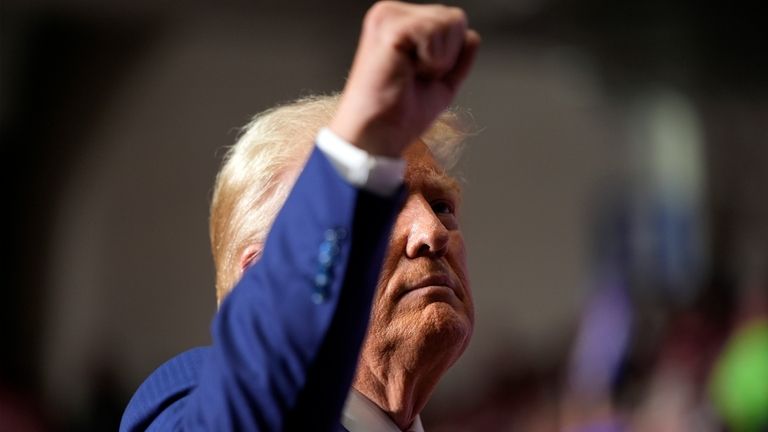 Republican presidential nominee former President Donald Trump gestures after speaking...