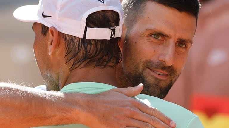 Serbia's Novak Djokovic greets Spain's Rafael Nadal after Nadal's training...