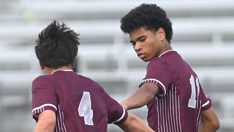 Luca Profeta of Garden City, left, gets congratulated by teammate Myles...