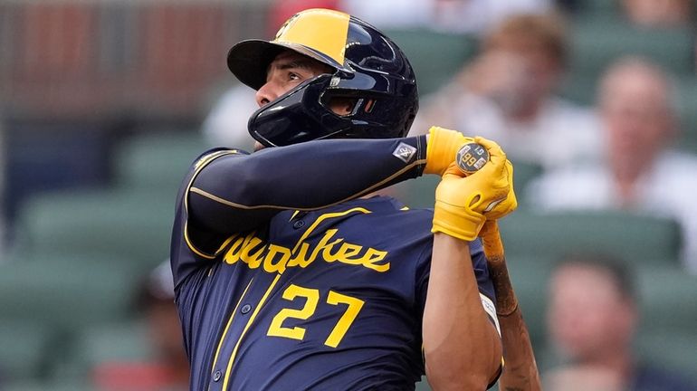 Milwaukee Brewers' Willy Adames follows through on a two-run home...