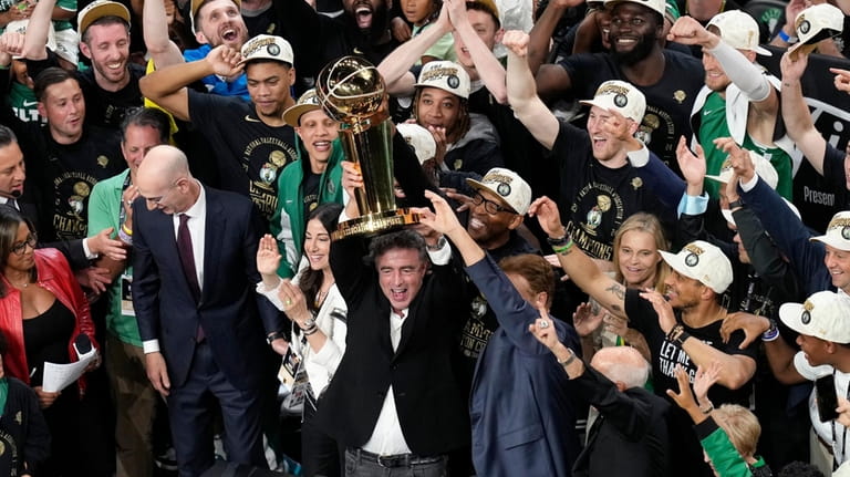 Boston Celtics owner Wyc Grousbeck raises the trophy after defeating...