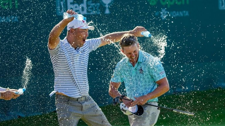 Jake Knapp of the United States is showered with water...