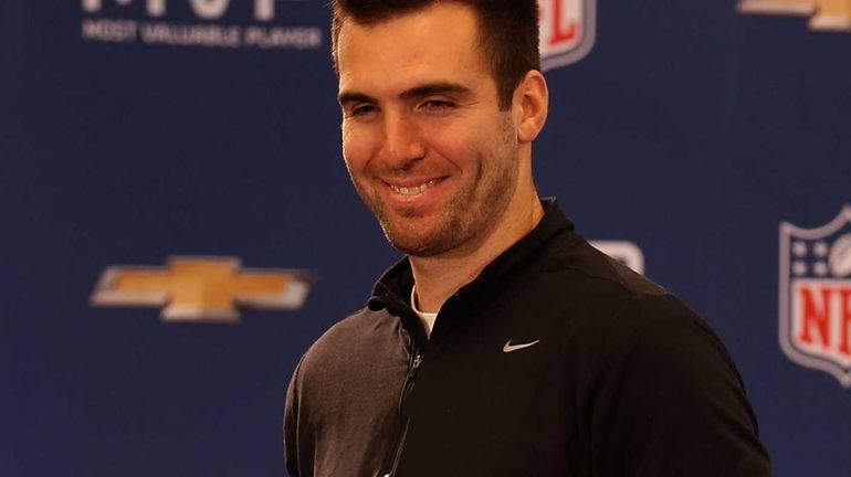 Baltimore Ravens quarterback Joe Flacco poses with the MVP trophy...