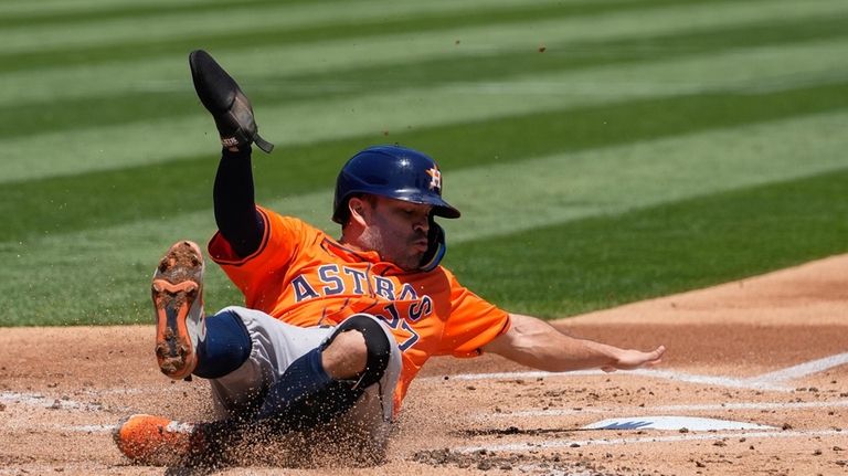 Houston Astros' Jose Altuve scores against the Oakland Athletics on...