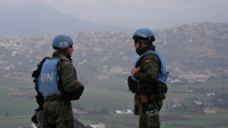Spanish U.N. peacekeepers stand on a hill overlooking the Lebanese...