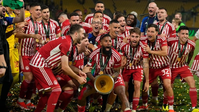 Olympiacos' Rodinei celebrates with the trophy at the end of...