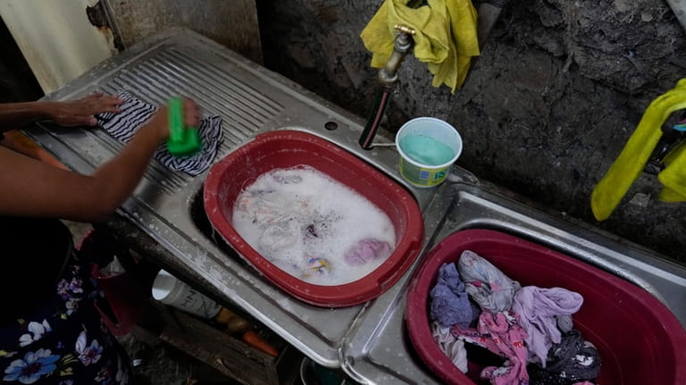 Graciela Mezcua washes her clothes inside of her home in...