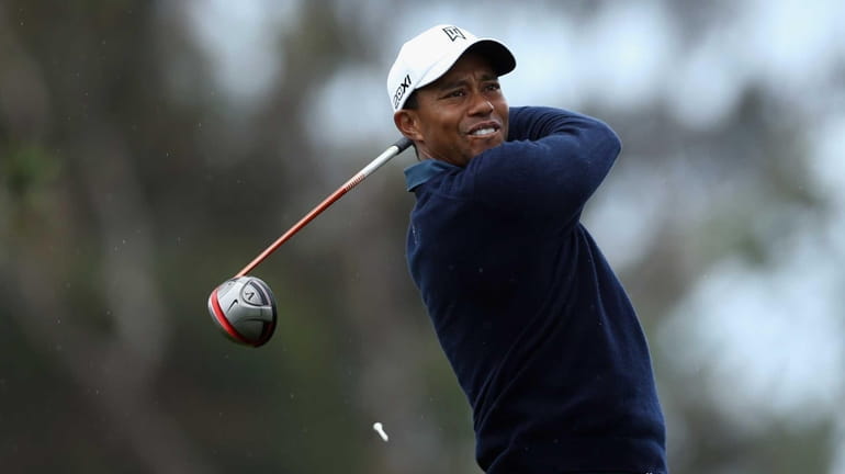 Tiger Woods hits a tee shot on the 11th hole...