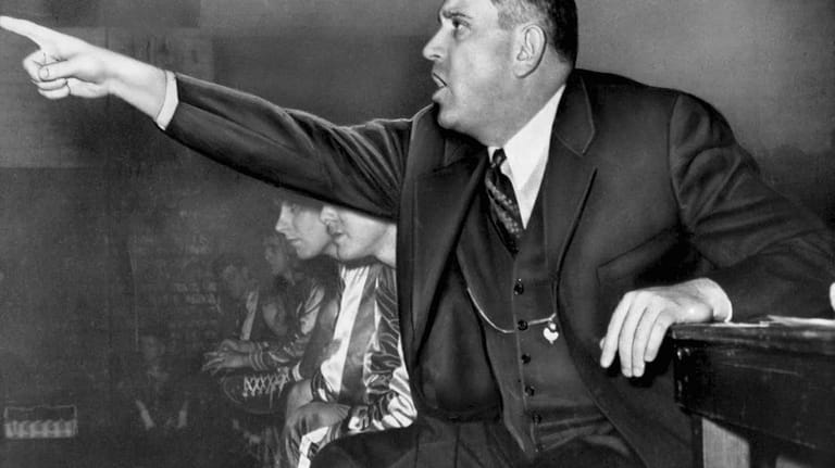 University of Kentucky coach Adolph Rupp gestures from the bench...