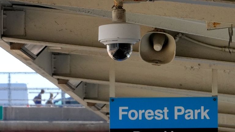 A security camera and speaker hang from the ceiling of...