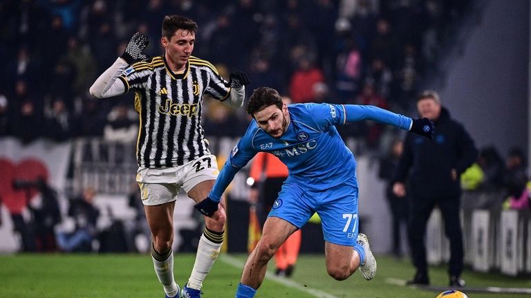 Juventus' Andrea Cambiaso, left, and Napoli's Khvicha Kvaratskhelia battle for...