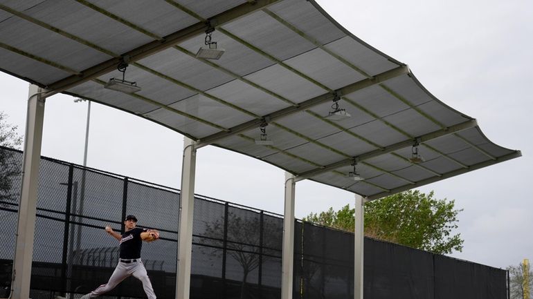 Washington Nationals pitcher Dylan Floro throws under cover in the...