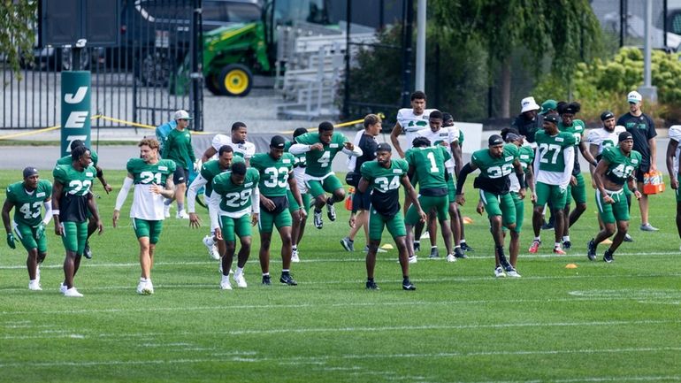 Jets players warm up during training camp, Tuesday, August 6,...