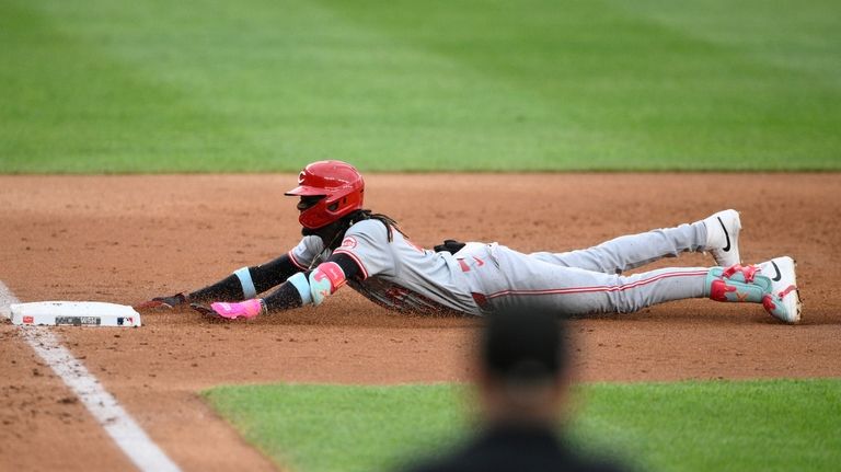 Cincinnati Reds' Elly De La Cruz slides safely into third...