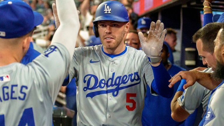 Los Angeles Dodgers' Freddie Freeman celebrates in the dugout after...